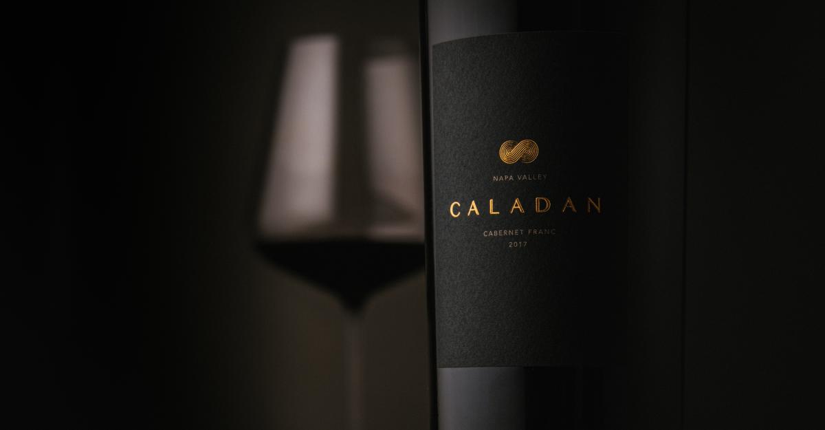 Closeup of Caladan 2017 Cabernet Franc bottle label with wine glass in background